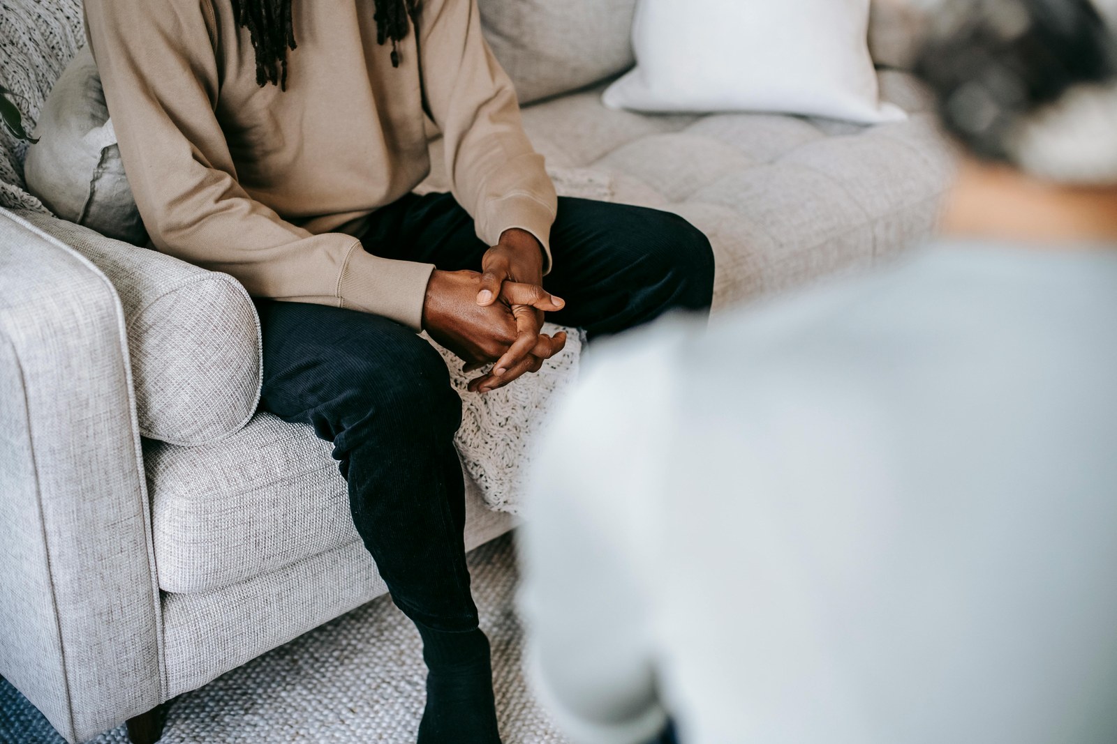A person seated calmly on a couch during a session, faces out of frame